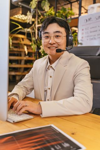 Portrait of a Man Wearing a Headset with a Microphone in an Office