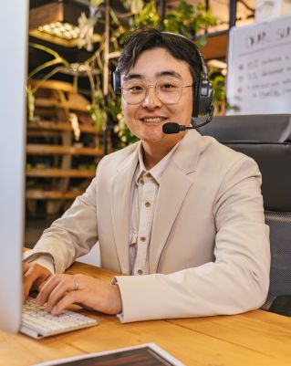 Portrait of a Man Wearing a Headset with a Microphone in an Office for Dangerous Goods Express Shipping