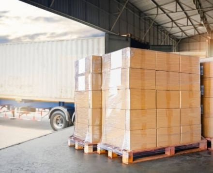 Loading dock being used for wood pallets, corrugated packaging looks to be loaded onto truck for LTL ground shipping.
