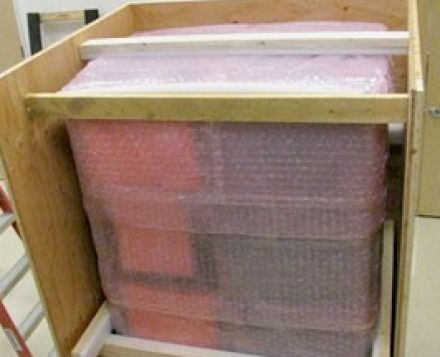 This wood shipping crate has pink-antistatic bubble wrap around crated electronic server rack for international shipping